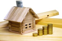 House standing at building materials and coins. Credit for the construction of wooden house
